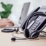 Casque téléphonique sur un bureau professionnel, représentant les outils pour un accueil téléphonique efficace.