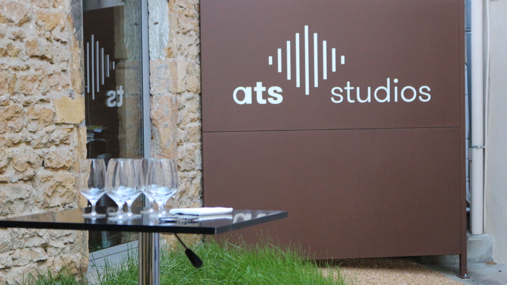 Une table  avec des verres de vin posée dans la cour des studios de l'entreprise ATS Studios.