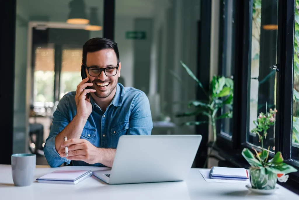 Homme souriant utilisant un répondeur mobile professionnel au bureau