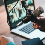 Personne utilisant un microphone et un ordinateur pour produire un podcast professionnel